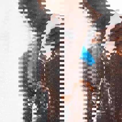 Person in shower squeezing product out of a bottle